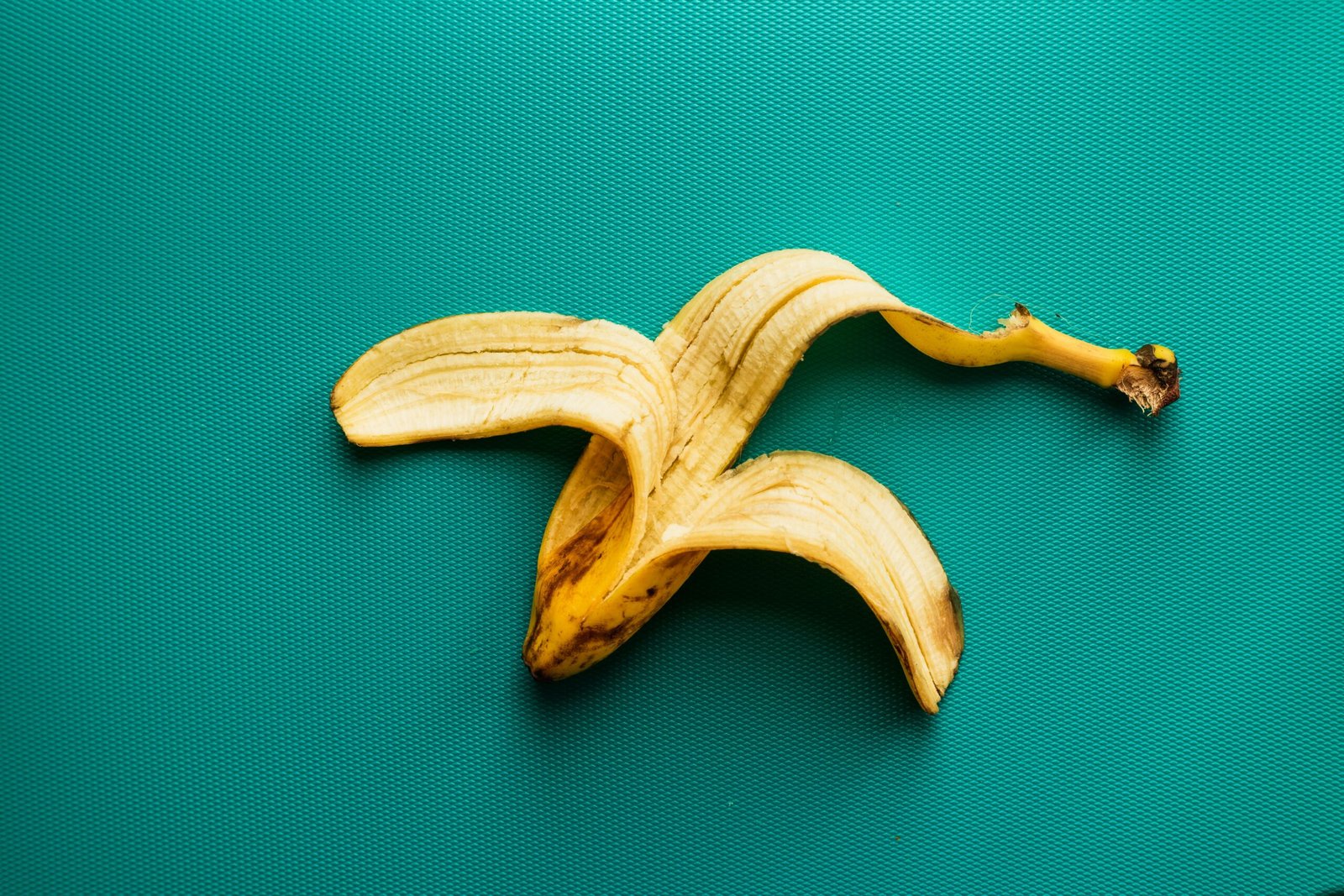 A banana peel on a green surface as an example of a kitchen food scrap; disposal categories depend on local guidance.